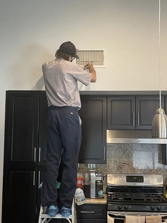 Technician inspecting an air vent during HVAC service in North Merritt Island